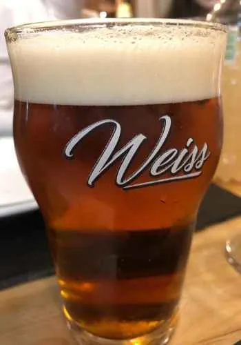 Pinta de cerveza roja con el logo de Weiss